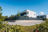 Sunbooster VERTICAL+ PV-Zaun-System als Sichtschutzzaun an einem modernen Wohnhaus